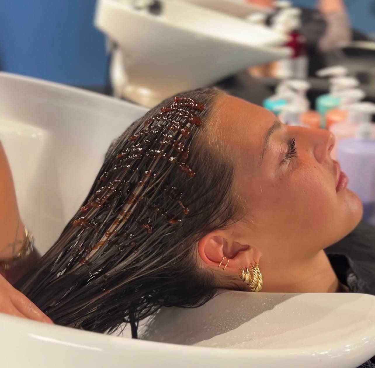 Young person getting a hair wash at a salon, highlighting care and relaxation.