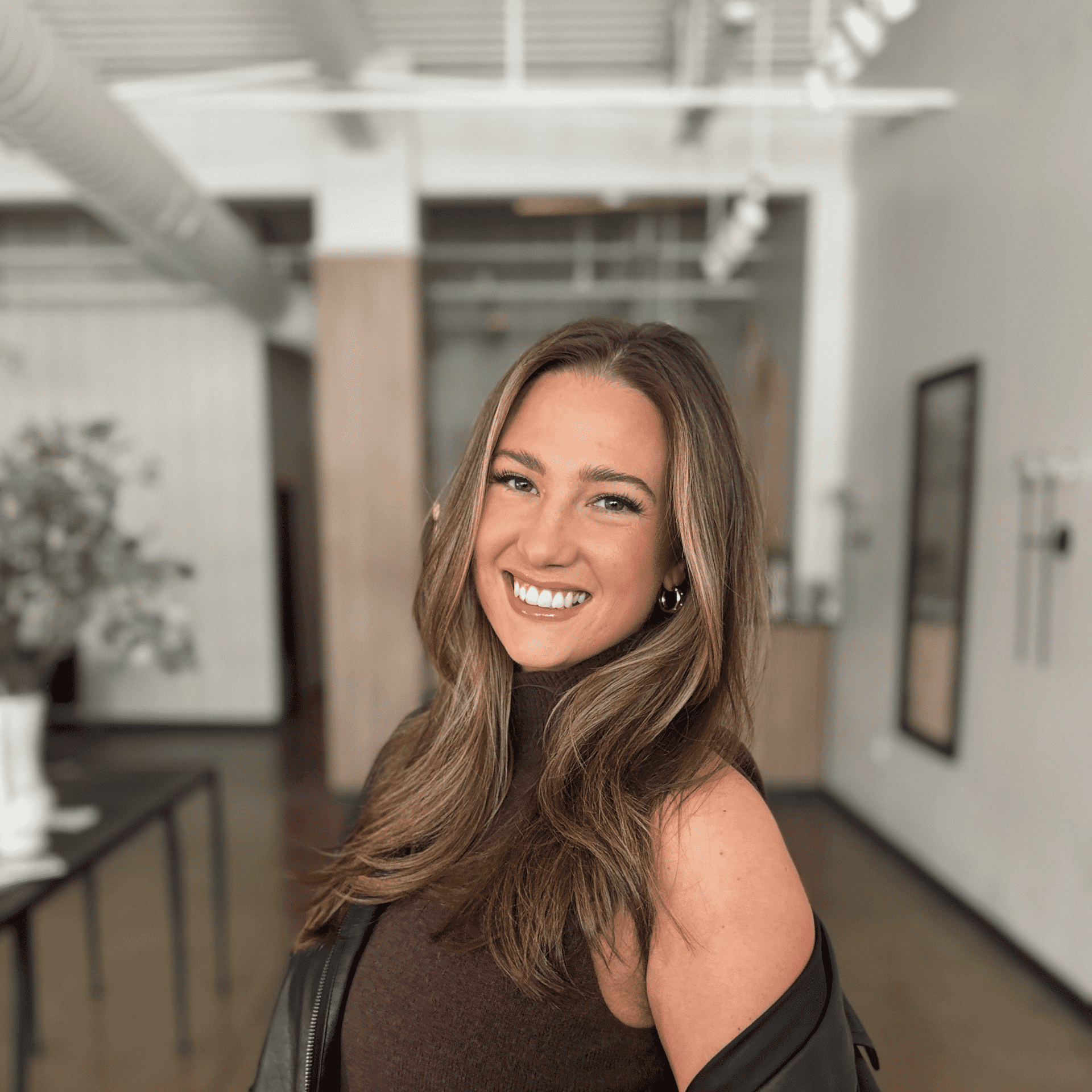 Portrait of Cassi Deluca, a professional stylist at Atelier, showcasing their expertise and style.